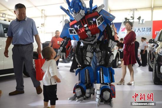 6月30日，車展上的“變形金剛”為主辦方造勢(shì)。當(dāng)日，2016第八屆呼和浩特國(guó)際汽車展覽會(huì)開(kāi)幕，展會(huì)為期5天，國(guó)內(nèi)外近80個(gè)汽車品牌以及30多家汽配商企參展，同時(shí)還設(shè)有汽保、老爺車、金融、改裝以及汽車行業(yè)相關(guān)服務(wù)等展示區(qū)，參展車型近500余款。中新社記者